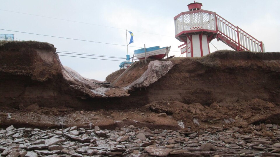 Cette petite chaloupe décorative et le petit phare semblent être à la veille de se retrouver à la mer, à Cap-Bateau, au Nouveau-Brunswick.