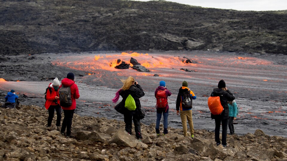 Des marcheurs photographiant la lave en fusion.