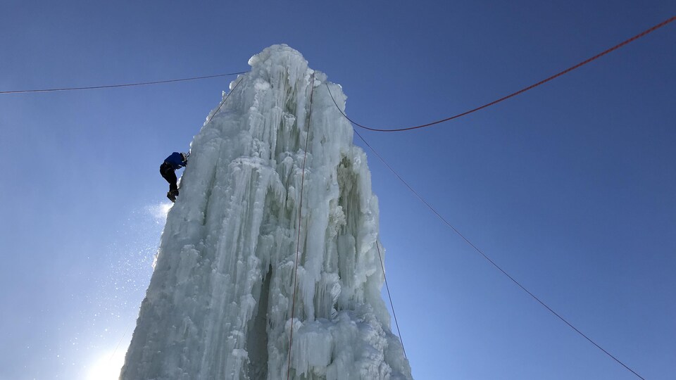 Um grimper escalade une tour de glace.