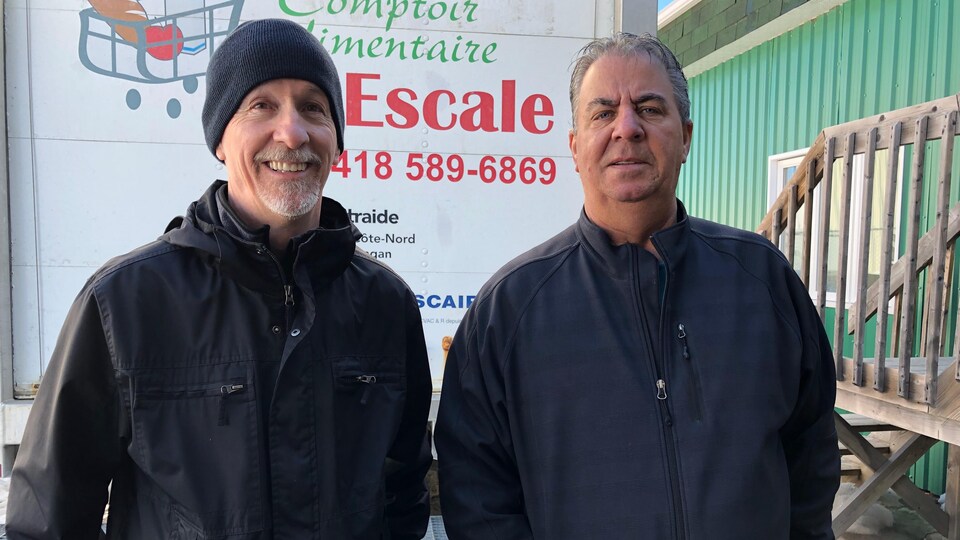 Deux hommes devant le camion réfrigéré du comptoir alimentaire l'Escale de Baie-Comeau. 