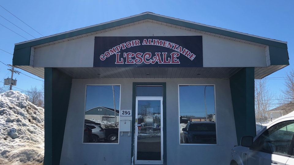 Un bâtiment sobre avec une affiche identifiant le comptoir alimentaire. 