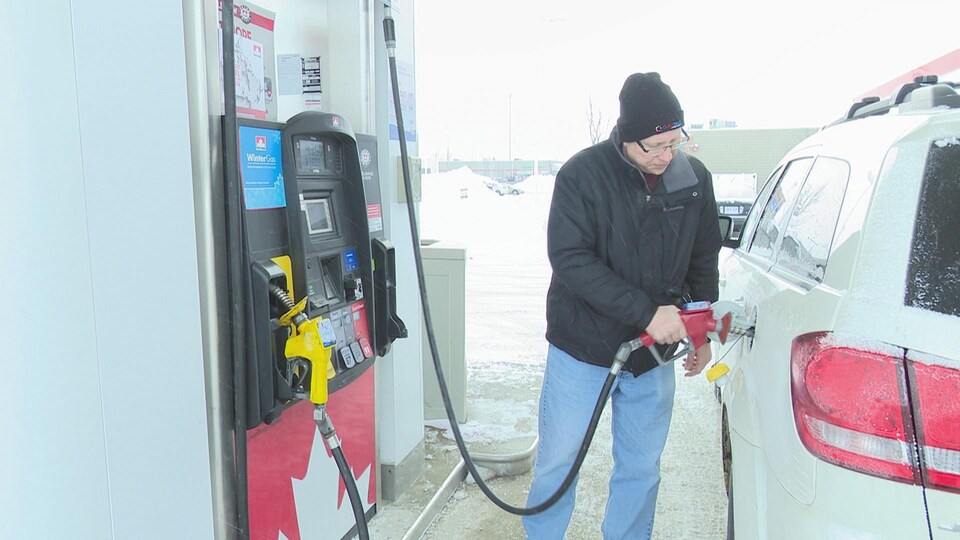 Un automobiliste fait le plein d'essence à une station-service.