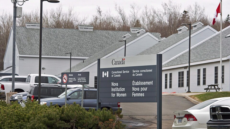 Photo de la prison et de l'enseigne devant le bâtiment.