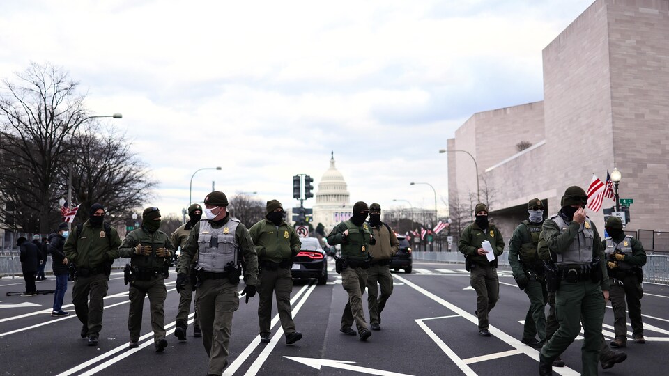 Des soldats marchent dans une rue.