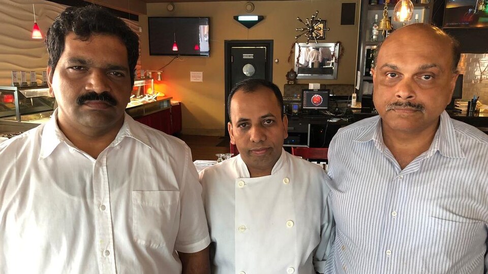 Trois hommes dans un restaurant à Ottawa.