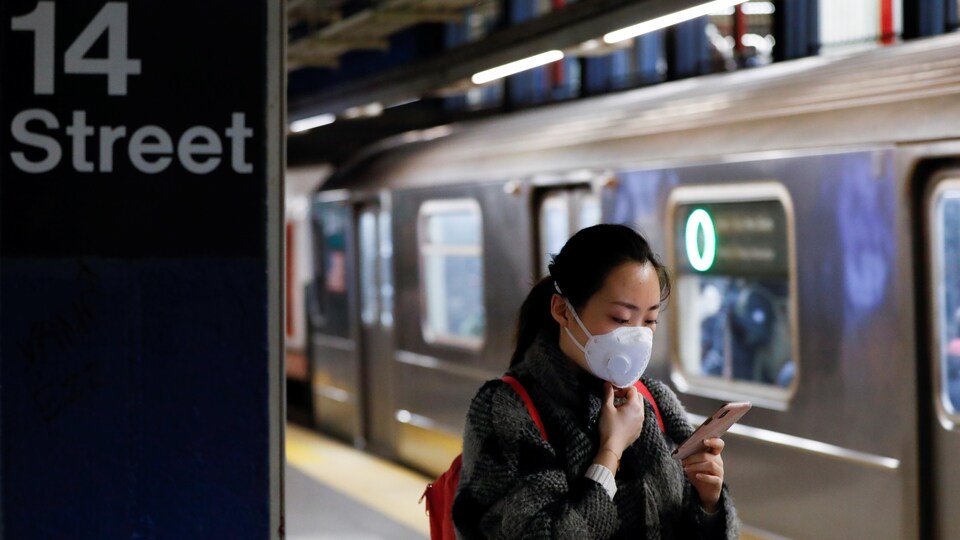 Une femme porte un masque dans le métro de New York.