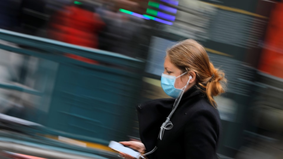 Une femme porte un masque chirurgical à New York.