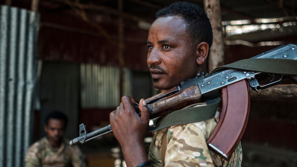 Un soldat tient un fusil mitrailleur.
