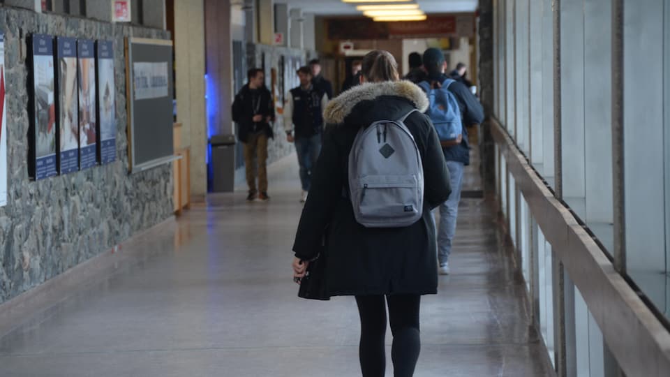 Des étudiants marchent dans le corridor du campus universitaire de la Laurentienne dans le Grand Sudbury. 