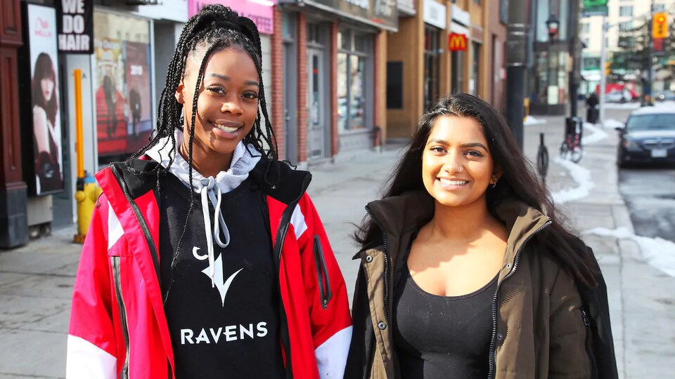 Deux jeunes femmes psoent pour la caméra dans une rue d'Ottawa au printemps.