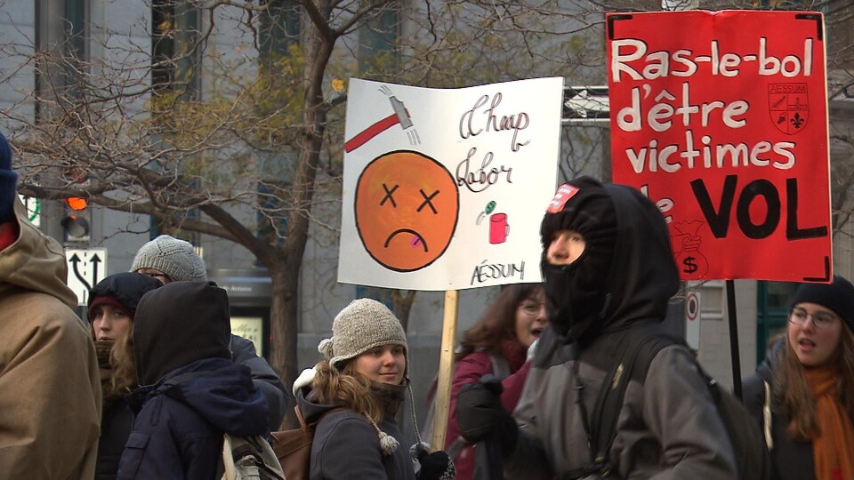 Des étudiants sont dans la rue à Montréal et tiennent des pancartes demandant la rémunération des stages