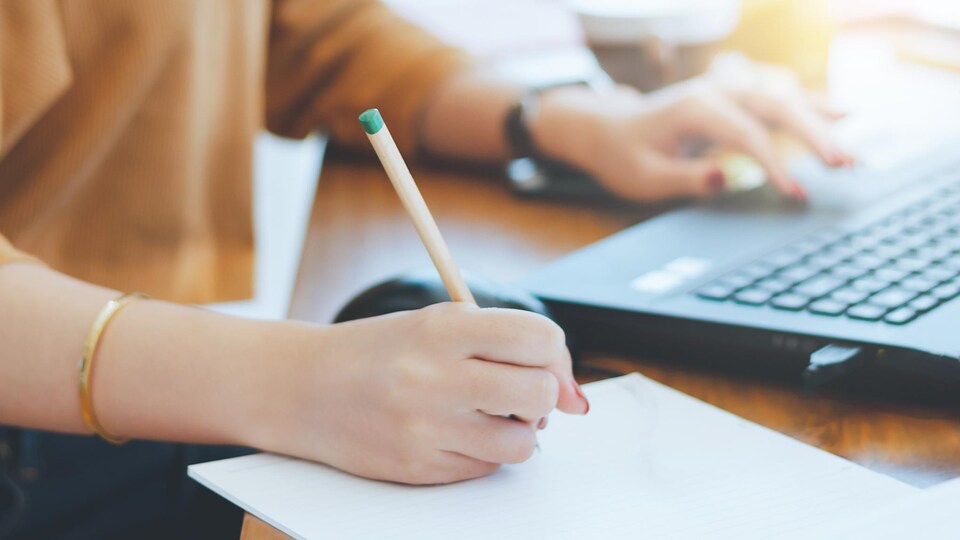 Une personne travaille près d'un ordinateur.