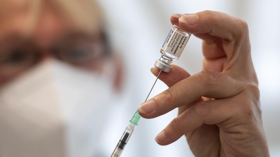 Yvonne Willmann, une employée des chemins de fer allemands, remplit une seringue à partir d'une fiole du vaccin contre la COVID-19 de l'entreprise pharmaceutique américaine Johnson & Johnson lors d'une campagne de vaccination à Berlin, en Allemagne, le 30 août 2021.