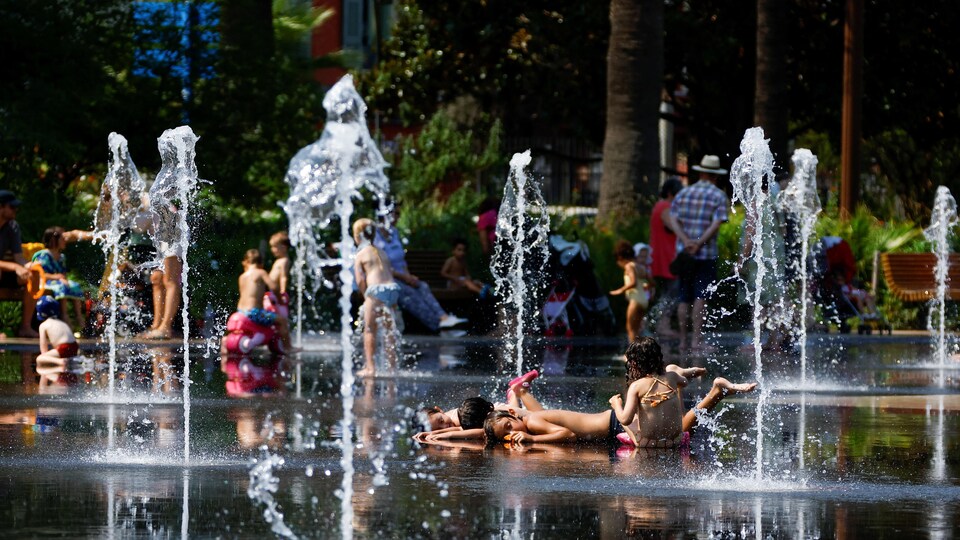 Des enfants s'amusent dans les jets d'eau d'une fontaine à Nice.
