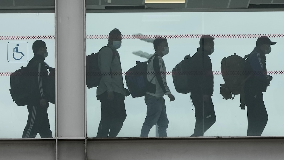 Les passagers rapatriés marchent dans l'aéroport.