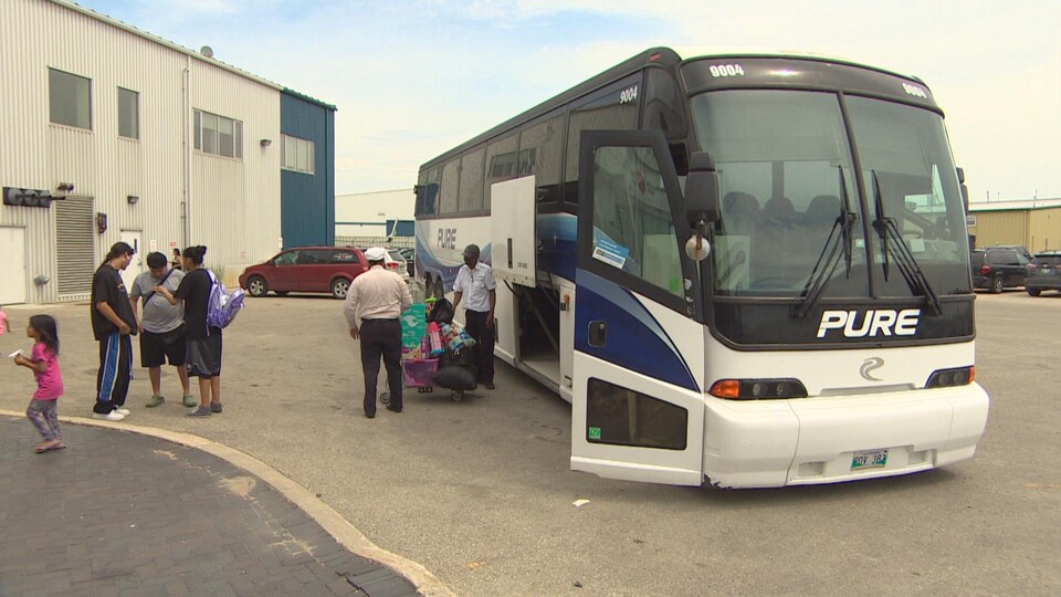 Des passagers s'apprêtent à monter dans un bus.