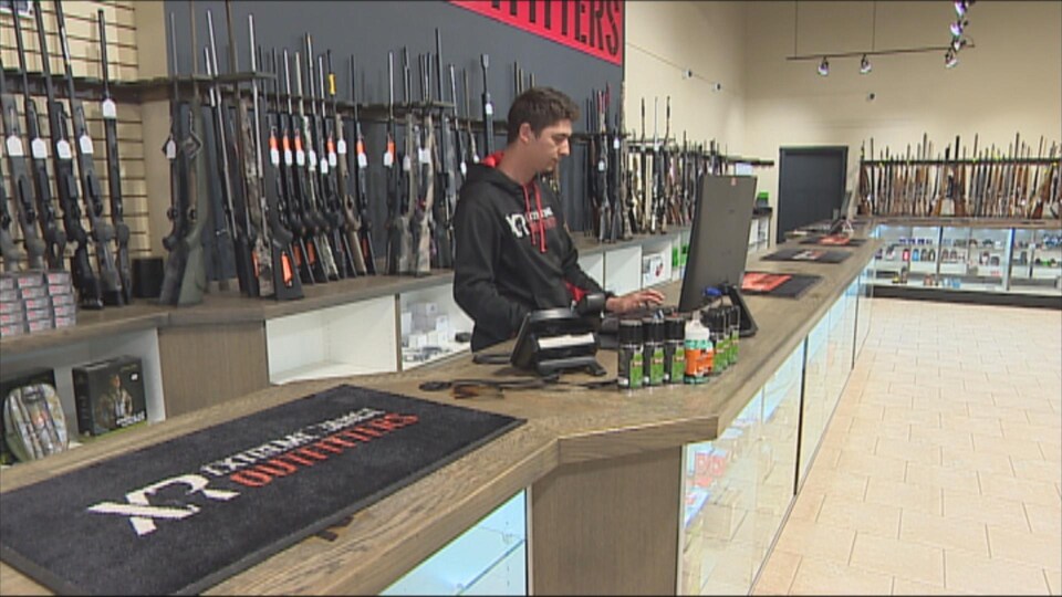 Un homme dans un magasin d'armes à feu.
