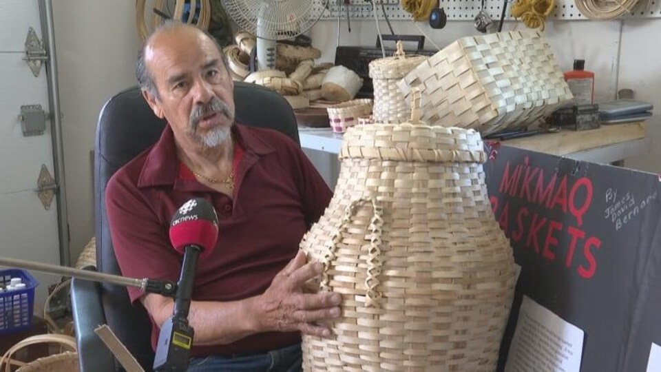 Keptin James Bernard, un membre de la Première nation de l’île Lennox, présente dans sa main un panier qu'il a fabriqué.