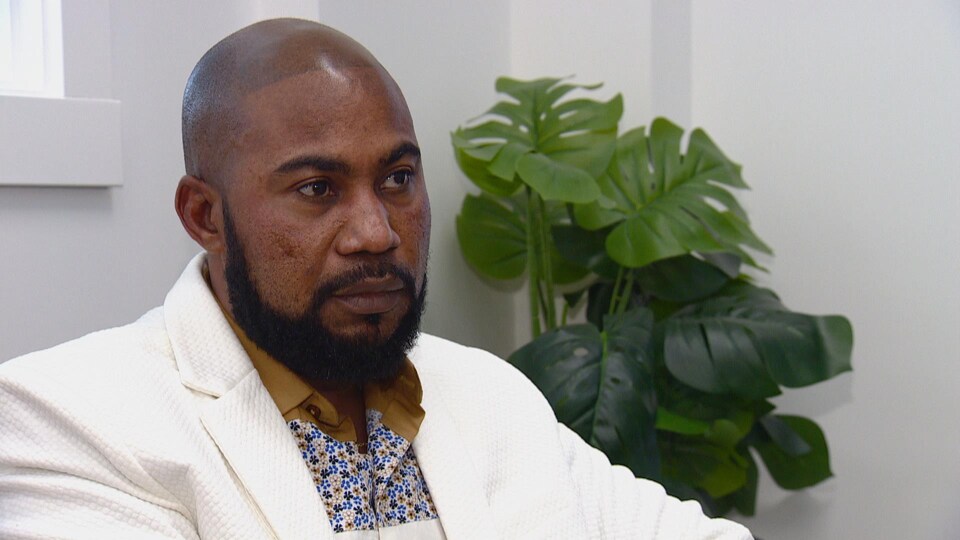Portrait du directeur en entrevue devant une plante verte.