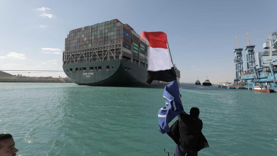 Un homme agite le drapeau égyptien devant le navire.