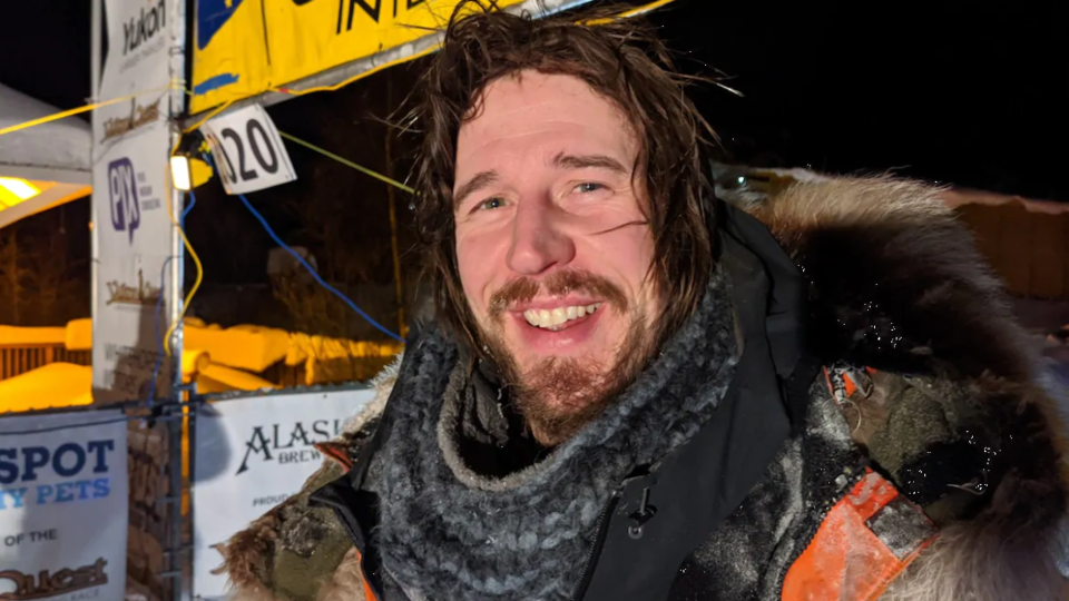 Plan serré de Brent Sass souriant devant le point d'arrivée, les cheveux mouillés et en bataille.