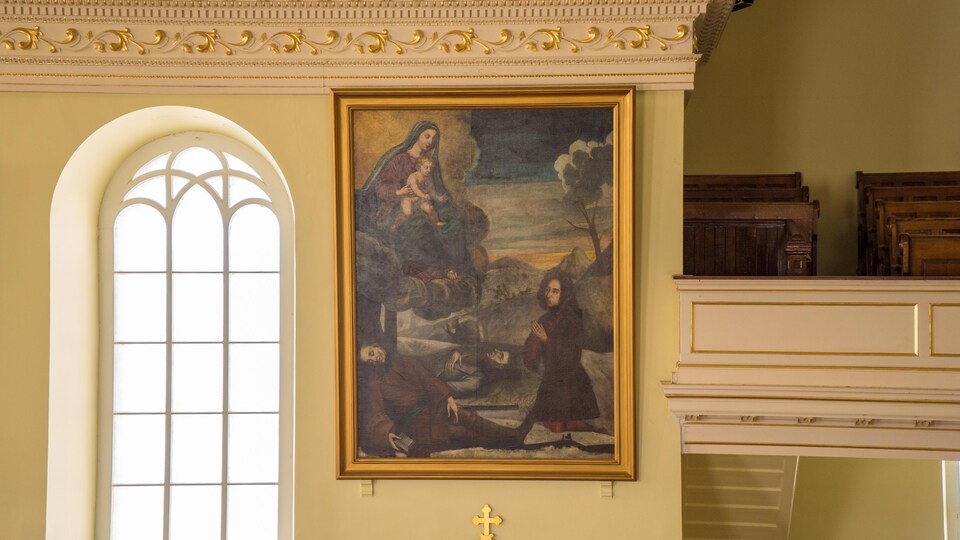 Le tableau accroché au mur de l'église.