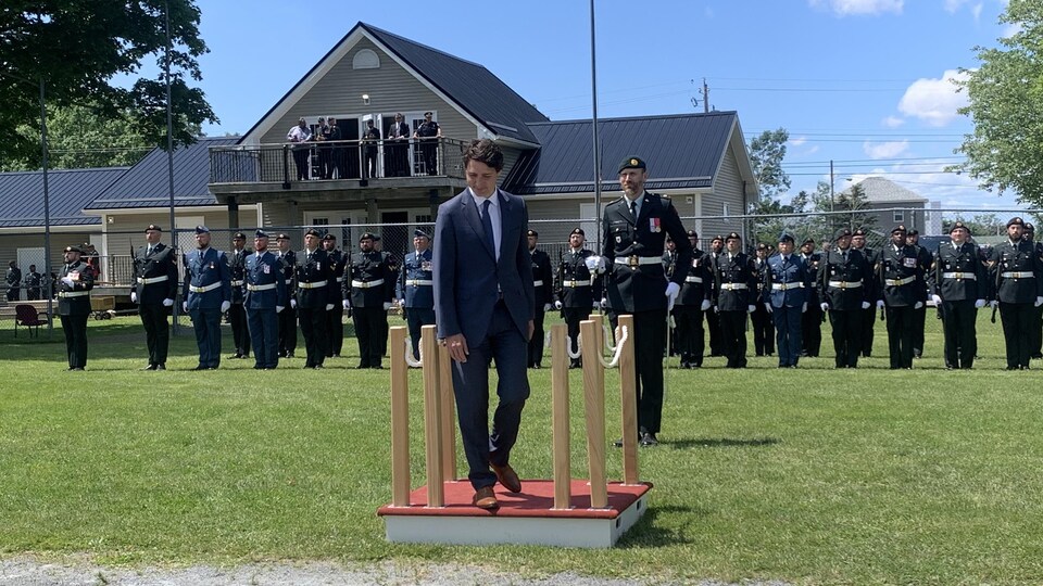 Devant des rangées de militaires en uniforme, Justin Trudeau est monté sur une petite estrade en bois installée dans un parc.