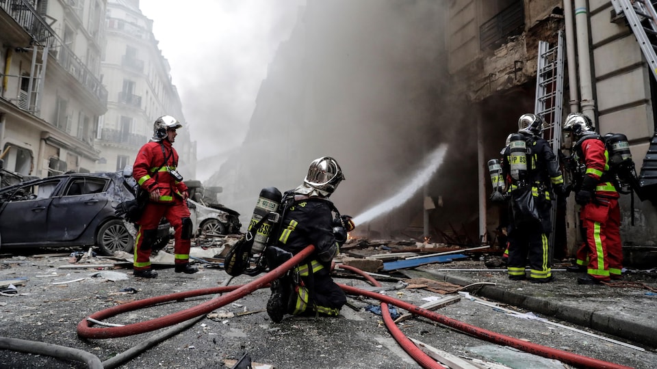 Les pompiers s'activent sur la scène de l'explosion, non loin du croisement des rues Sainte-Cécile et Trevise, dans le 9e arrondissement de Paris.