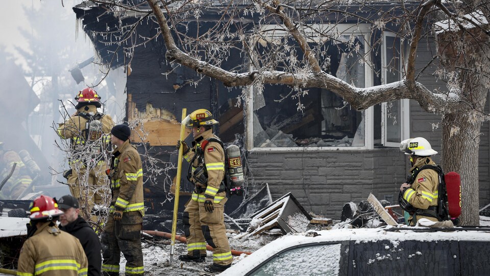 Des pompiers sur les lieux de l'explosion d'une maison. 
