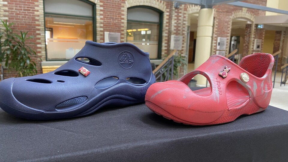 Des chaussures Crocs. Une paire rouge et une paire bleue.