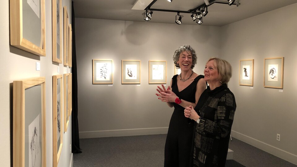 Deux femmes devant des oeuvres exposées dans une galerie d'art