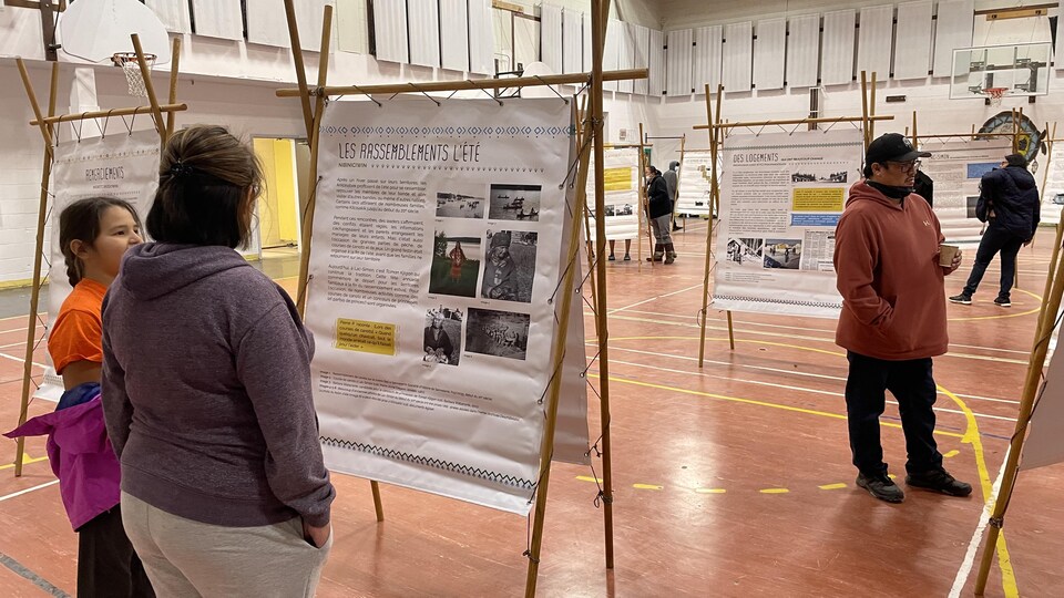Des gens se promènent pour lire des panneaux historiques.