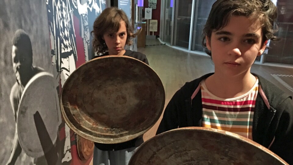 Juliette et Charlotte Bolduc tiennent un couvercle de poubelle en guise de bouclier.