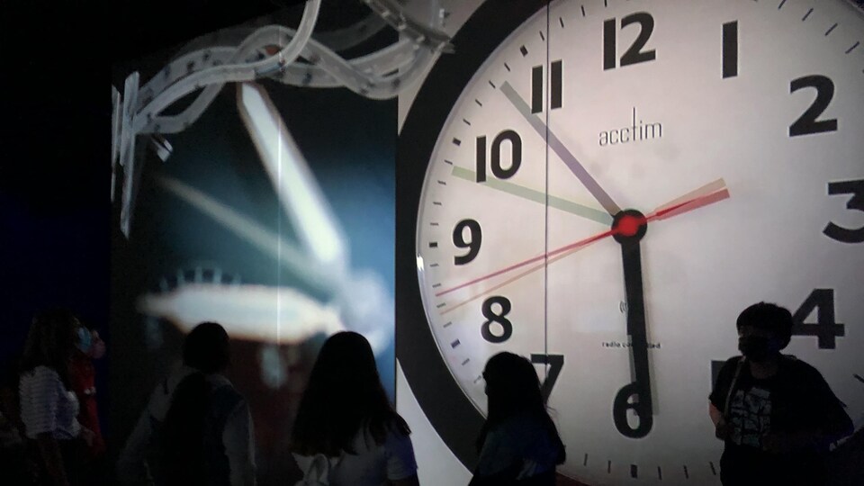 Un horloge sur un grand écran.