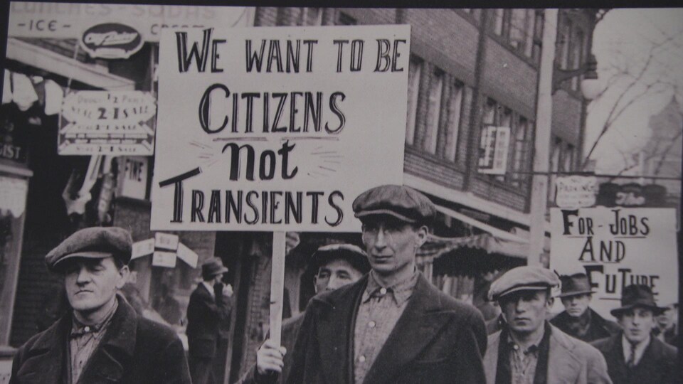 Des hommes brandissent des pancartes.