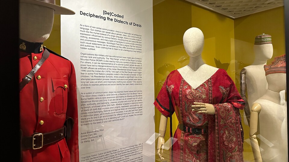 Une exposition de vêtement avec un mannequin portant un uniforme de la GRC et un autre portant une robe. 