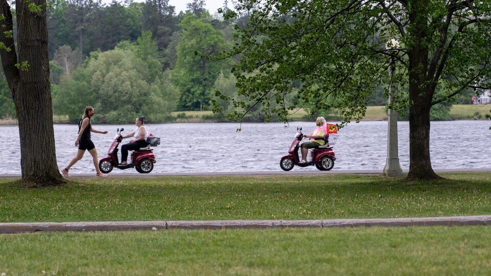 Des gens se promène sur une piste cyclable en bordure d'un cours d'eau.