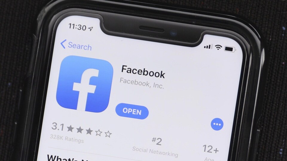 L’écran d’un téléphone cellulaire affiche l'application de Facebook.