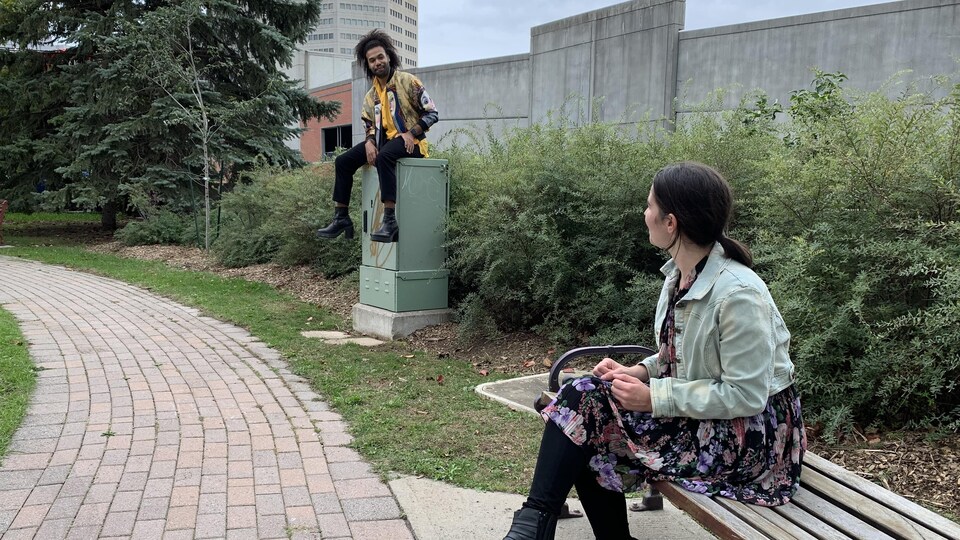 Les comédiens David Bélizaire et Clémence Roy-Darisse sont assis dans un parc du Vieux-Hull et se regardent.