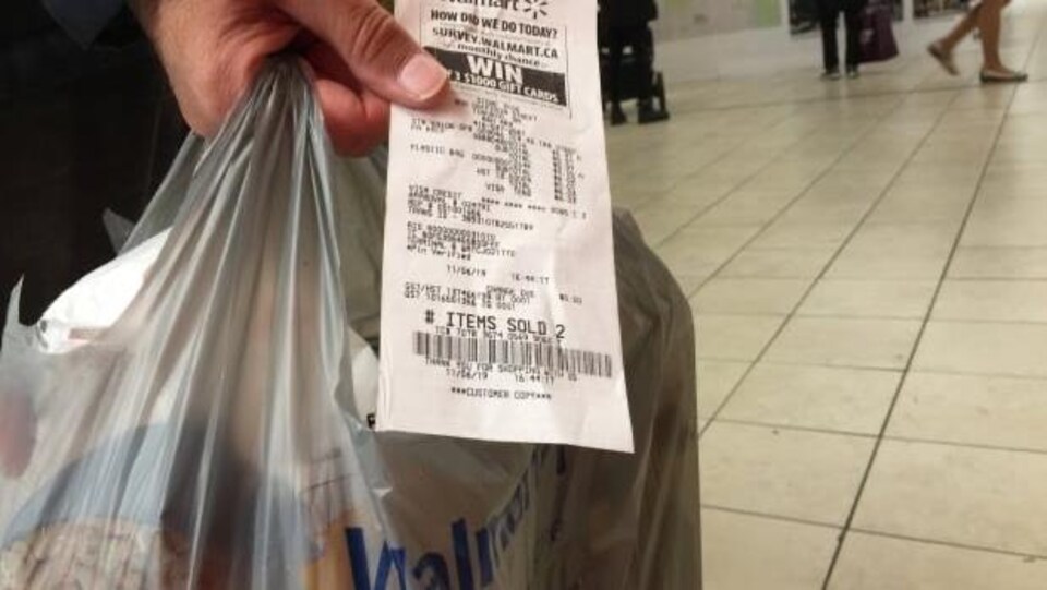 Un client montrant sa facture Walmart.