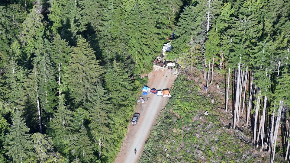 Une route vue de haut avec des tentes et des voitures.