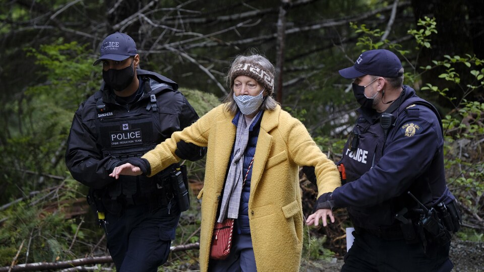 Une femme est arrêtée par des policiers à Fairy Creek.