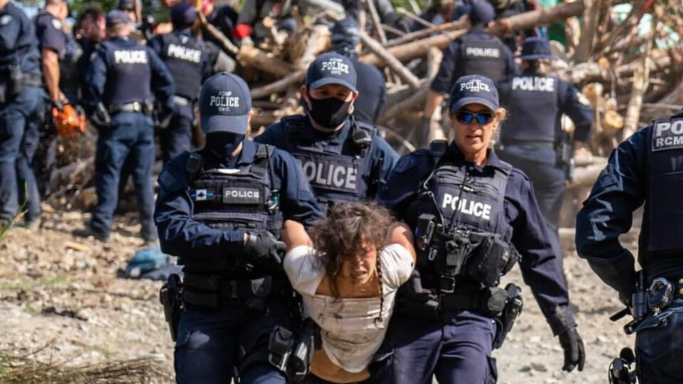 Une femme est transportée par 3 agents de la GRC à Fairy Creek.