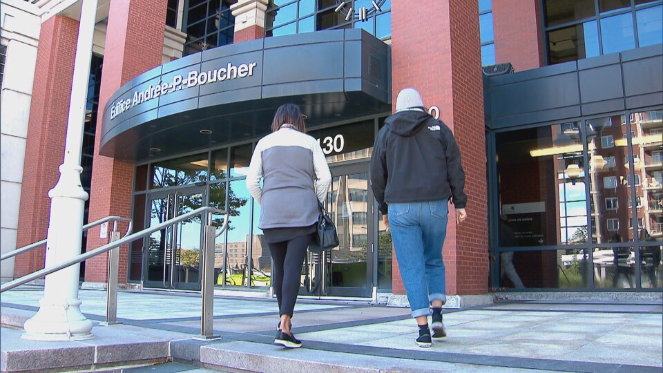 Deux femmes accordent une entrevue devant un poste de police.