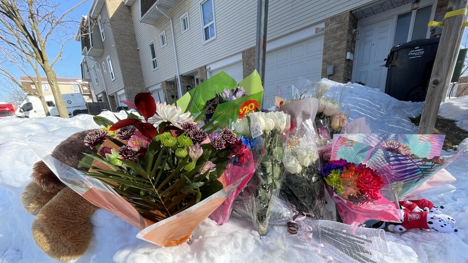 Des fleurs déposées devant une maison.