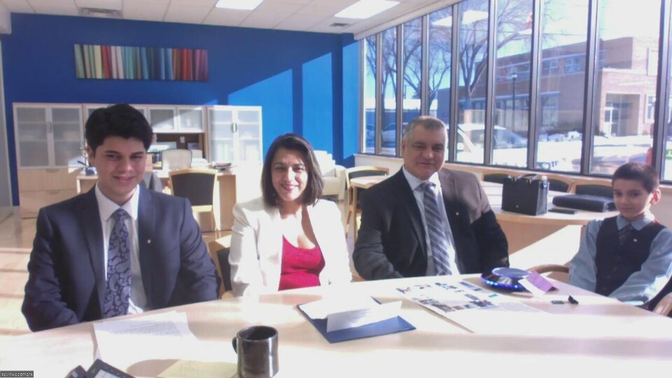 De gauche à droite : Victor Mauricio, Lesi Cardoza, Victor Santos et Edward Santos attendent le début de la cérémonie d'assermentation de la citoyenneté canadienne le mercredi 1er février à Moosomin, en Saskatchewan.