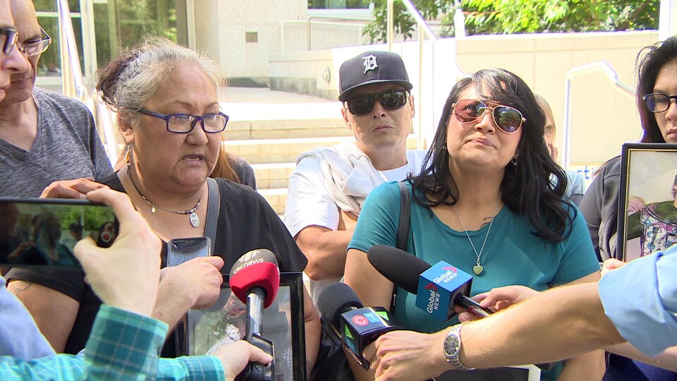 Deux femmes autochtones sont devant la Cour du Banc de la Reine et parlent au micro des journalistes.