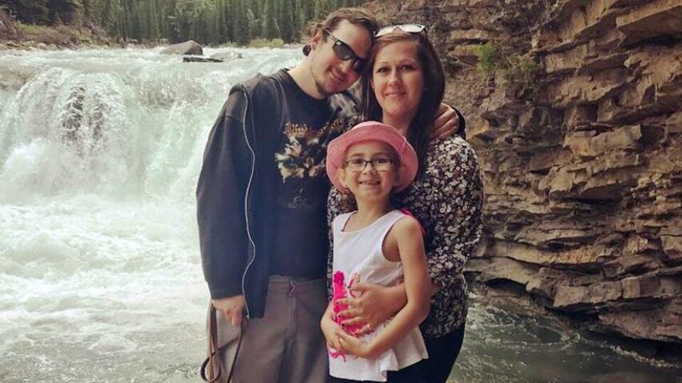 Un couple et une enfant devant une chute.