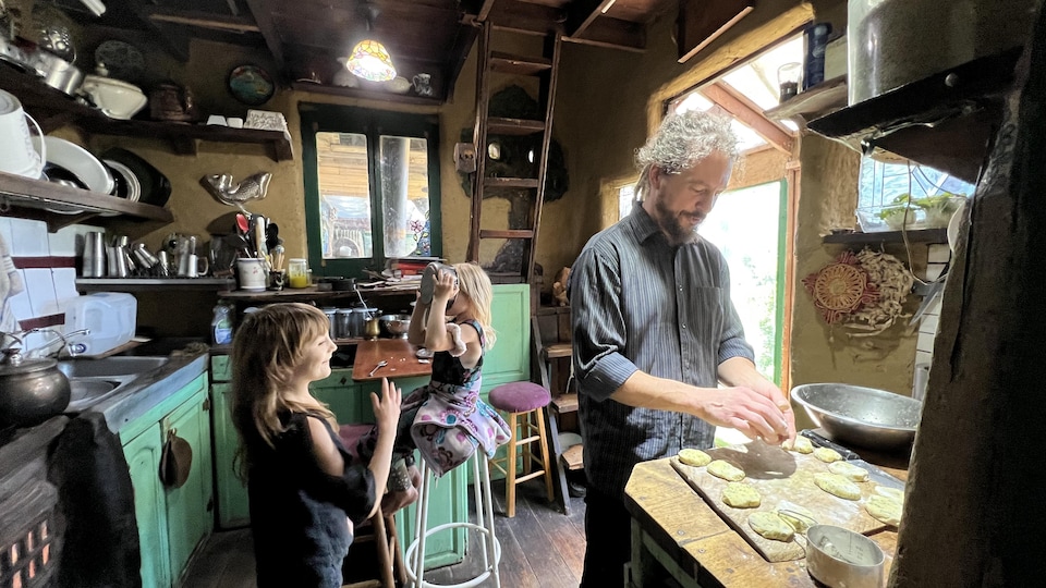 Bryce Murph'Ariens prépare à manger à ses filles Sage et Aurora dans la cuisine de leur maison.