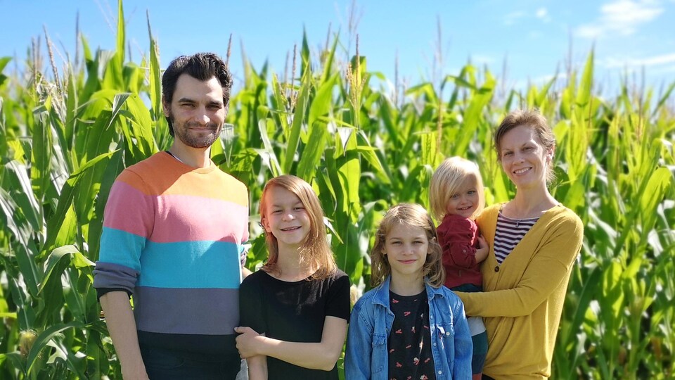 Guillaume Boudrias-Plouffe, Émilie Levert, et leurs enfants Emeline, Léo et Zéphir prennent la pose devant un champ.